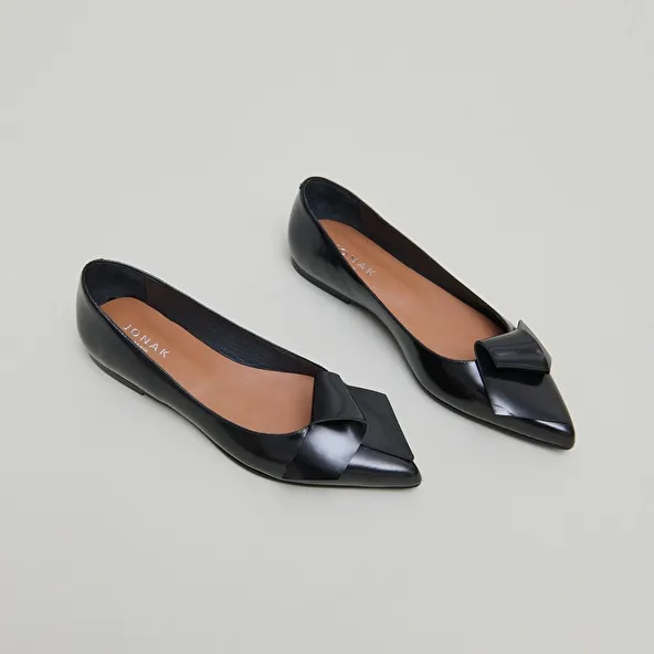 Ballet flats with pointed toes in black glazed leather