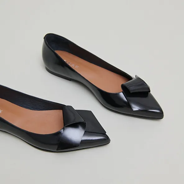 Ballet flats with pointed toes in black glazed leather