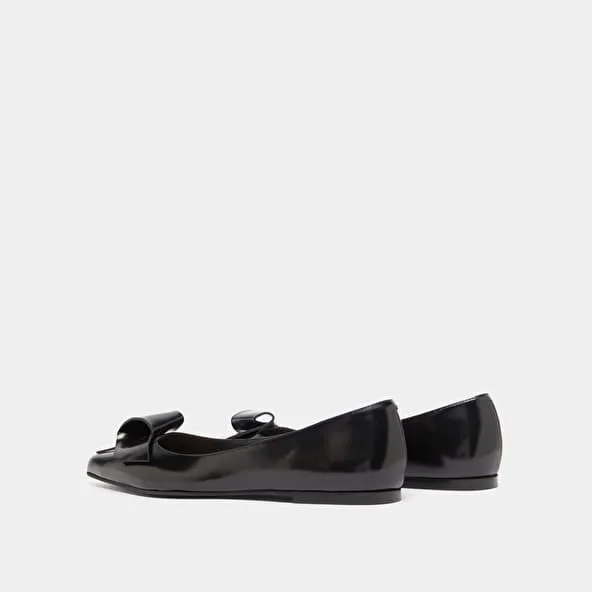 Ballet flats with pointed toes in black glazed leather